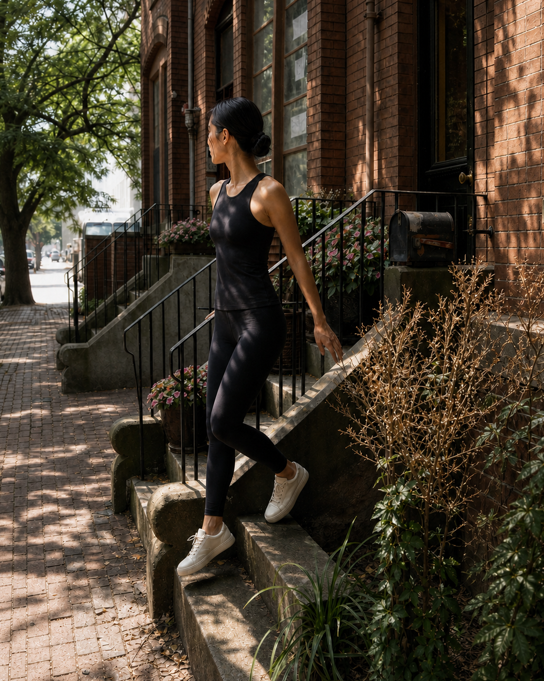 Black Contour Racer Tank in dappled light at a brownstone studio exit