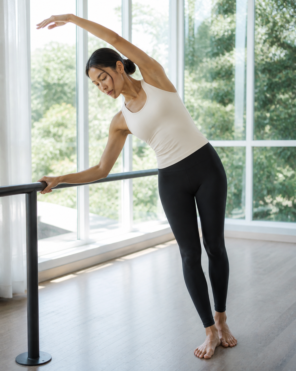 Ivory Contour Racer Tank during a barefoot side stretch at the barre.