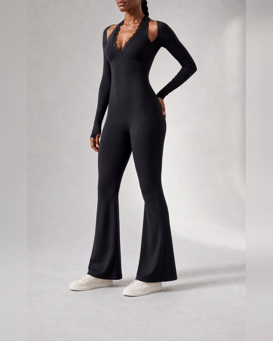 Side view showing the continuous shape of the black lace-trim one-piece.