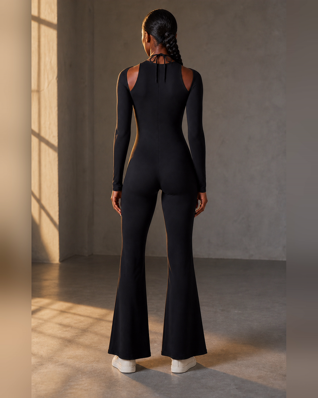 Rear view of the black lace-trim flared one-piece.