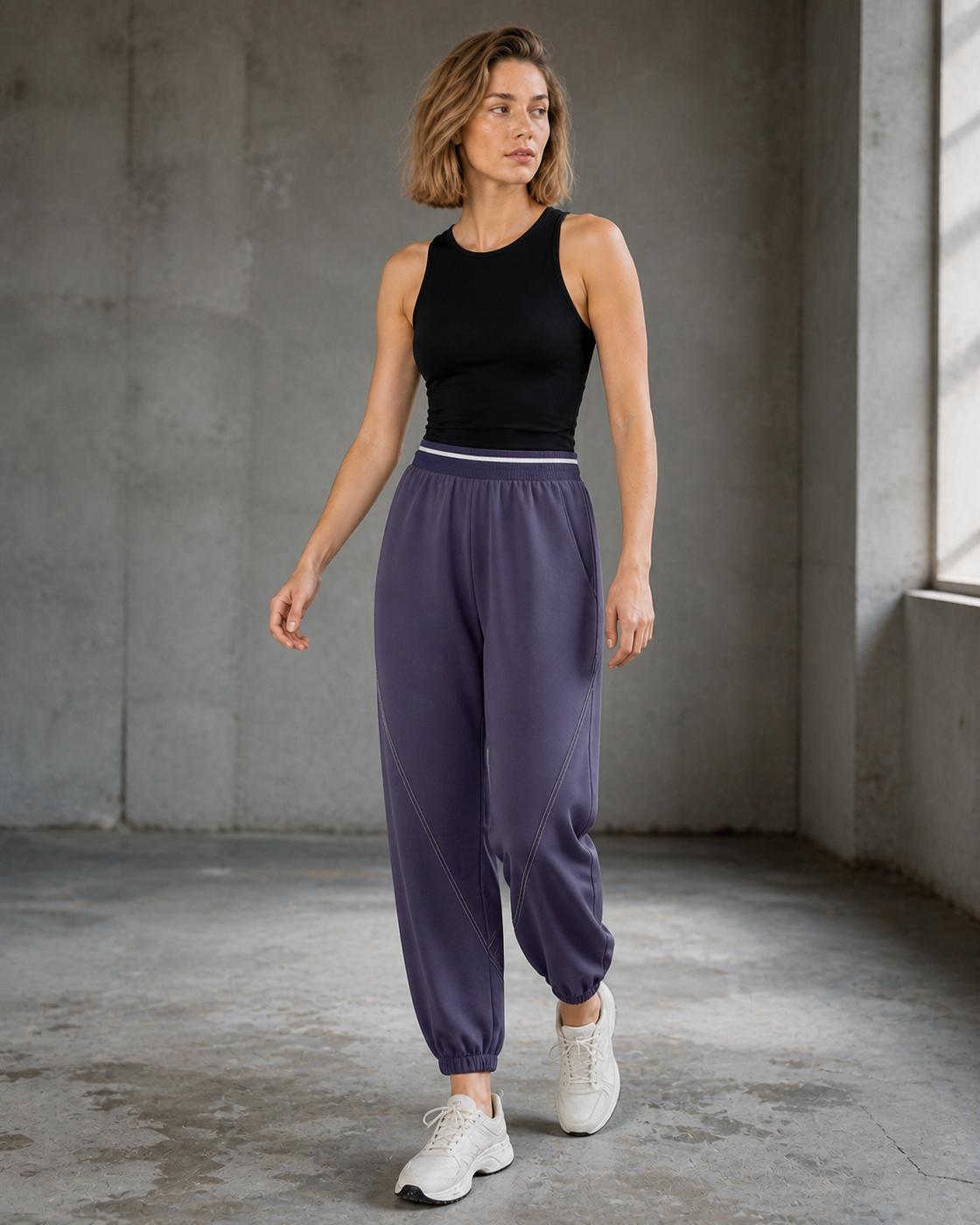 Model wearing Purple relaxed training joggers in a concrete daylight studio.